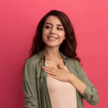 smiling-looking-side-young-beautiful-girl-wearing-olive-green-t-shirt-putting-hand-chest-isolated-pink-wall_141793-91467