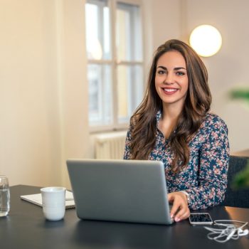 young attractive businesswoman in modern office working on laptop