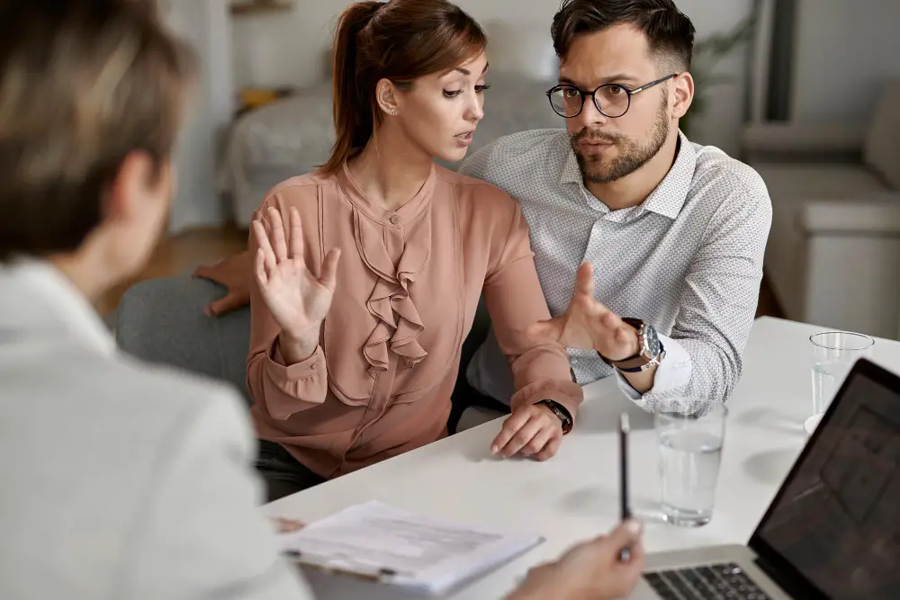 young-couple-communicating-with-insurance-agent-during-meeting