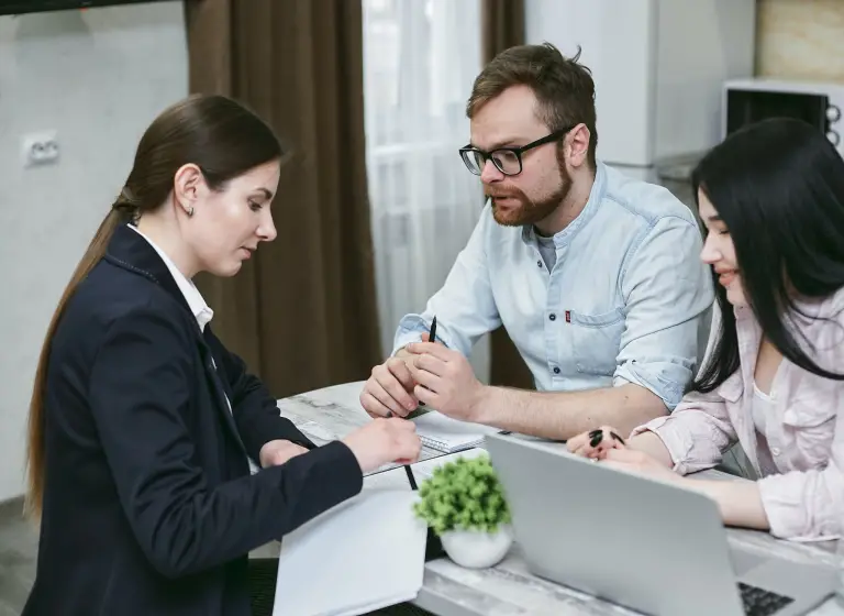 A photo showing three sitting at a table.