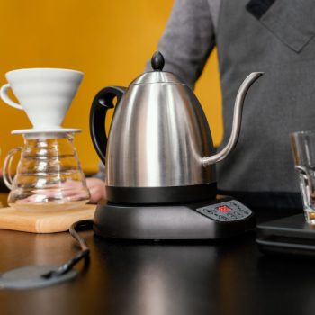 front-view-male-barista-preparing-coffee-with-kettle-filter