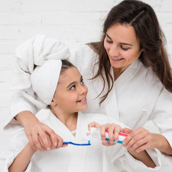 mother-helping-her-girl-brush-her-teeth (1)