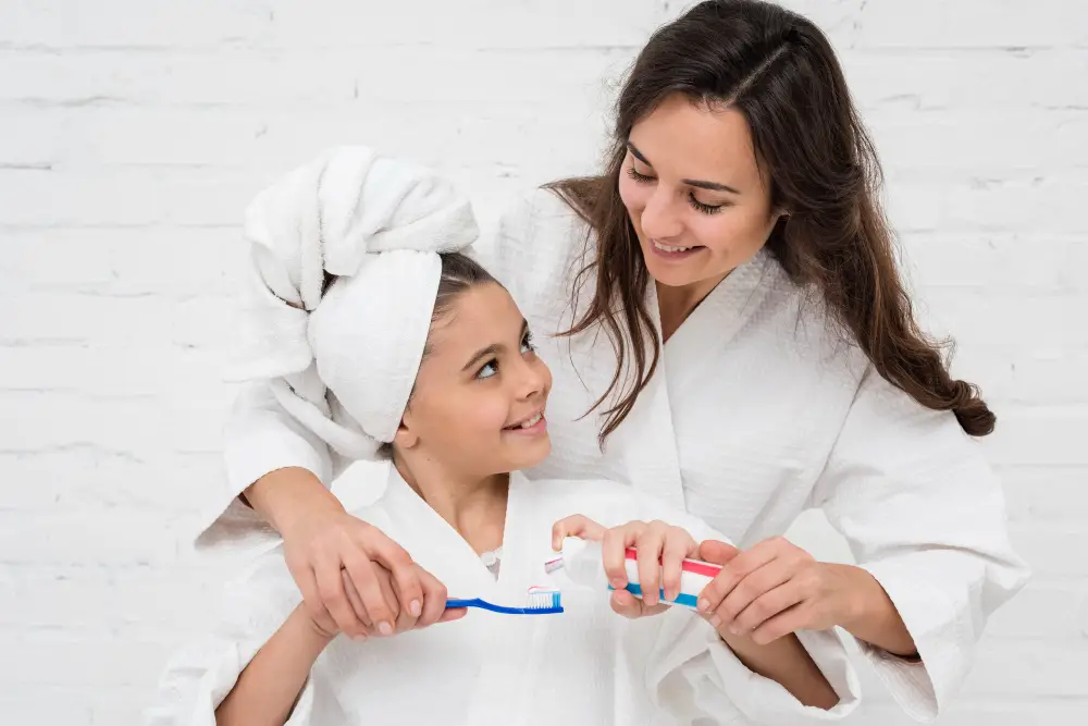 mother-helping-her-girl-brush-her-teeth (1)