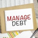 text-manage-debt-on-notepad-and-pen-on-wooden-background-photo