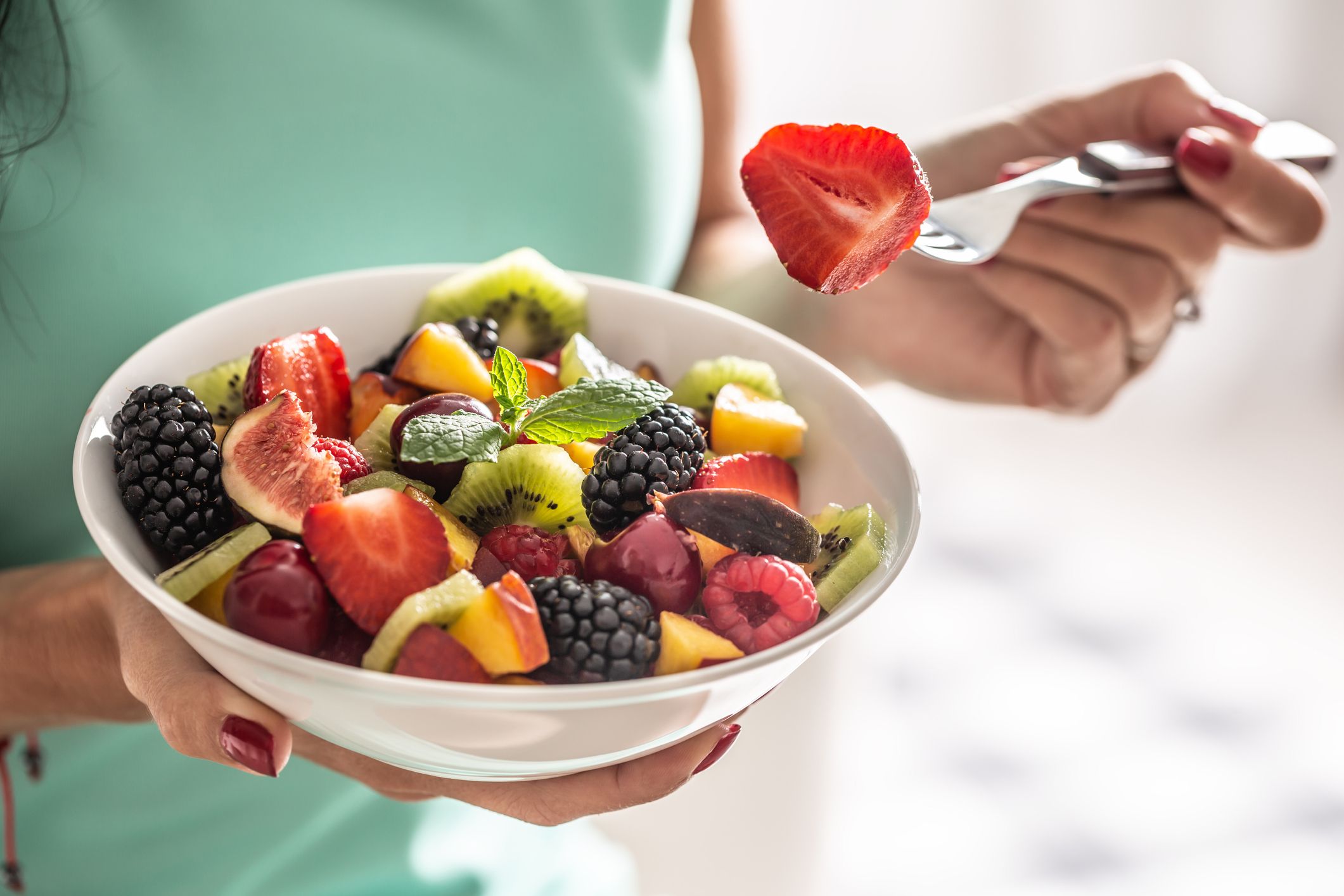 woman-breakfasts-a-fruit-salad-high-in-vitamins-and-royalty-free-image-1690494564