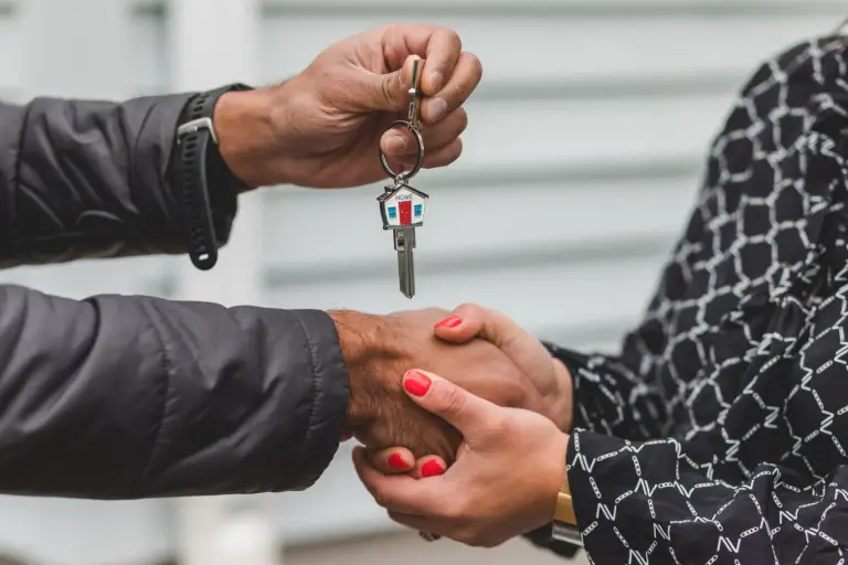 A photo showing a person transferring keys to another person.