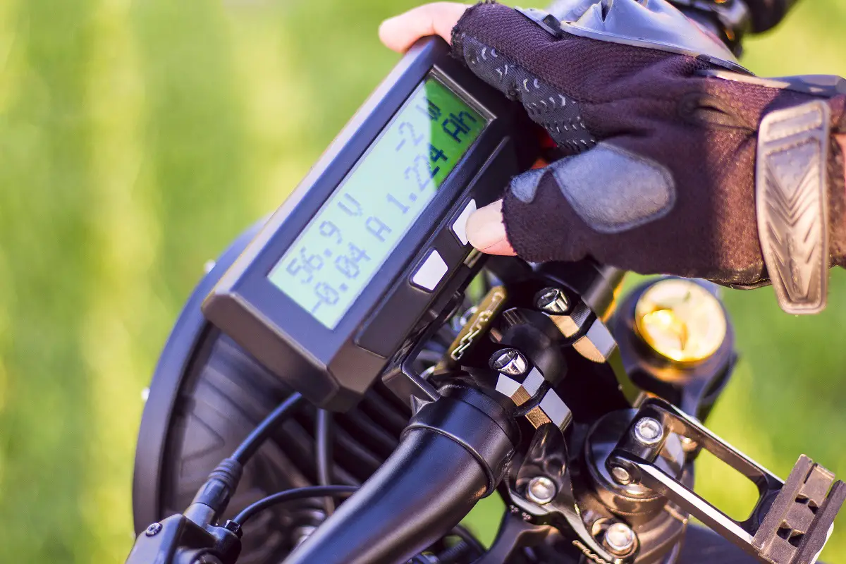 close-up-man-hand-clicking-mode-button-monitor-electric-bike