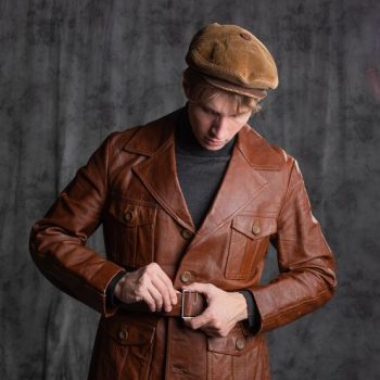 young-man-retro-secret-agent-guy-brown-leather-jacket-flat-cap-with-gun-his-hand_125374-4367
