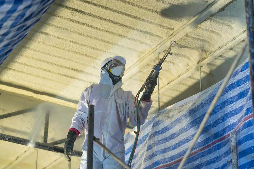 A man is spraying foam insulation