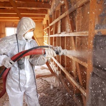 Spraying cellulose insulation on the wall