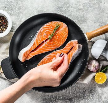 chef-salts-raw-salmon-steak-in-a-frying-pan-healt-2021-12-09-10-54-19-utc-min
