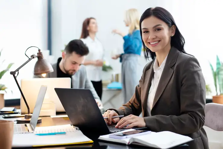 A woman with a laptop is doing accounting work.