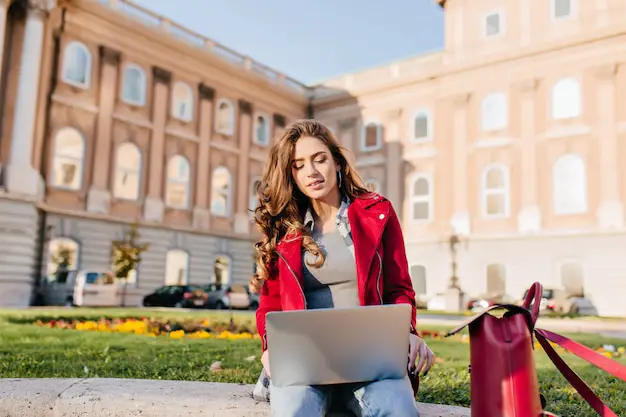 outdoor-portrait-serious-curly-female-student-sitting-with-laptop-ground_197531-6965 (1)