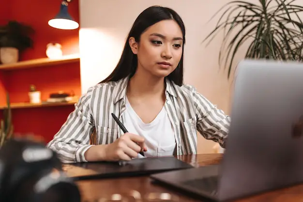 serious-brown-eyed-asian-woman-working-office-with-laptop-holding-pen_197531-19565