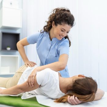 young-woman-doctor-chiropractor-osteopath-fixing-lying-womans-back-with-hands-movements-during-visit-manual-therapy-clinic-professional-chiropractor-during-work