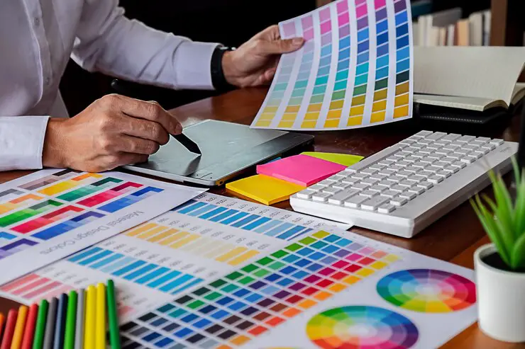 midsection-entrepreneur-using-graphic-tablet-while-holding-color-swatch-desk-office_1048944-23869103