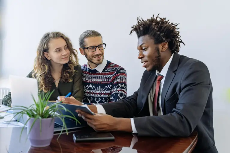 A loan agent discussing financing options with clients in an office setting