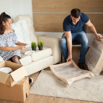 young-couple-moving-new-home-unpacking-carboard-boxes-almost-done-moving_1200x800_1_optimized