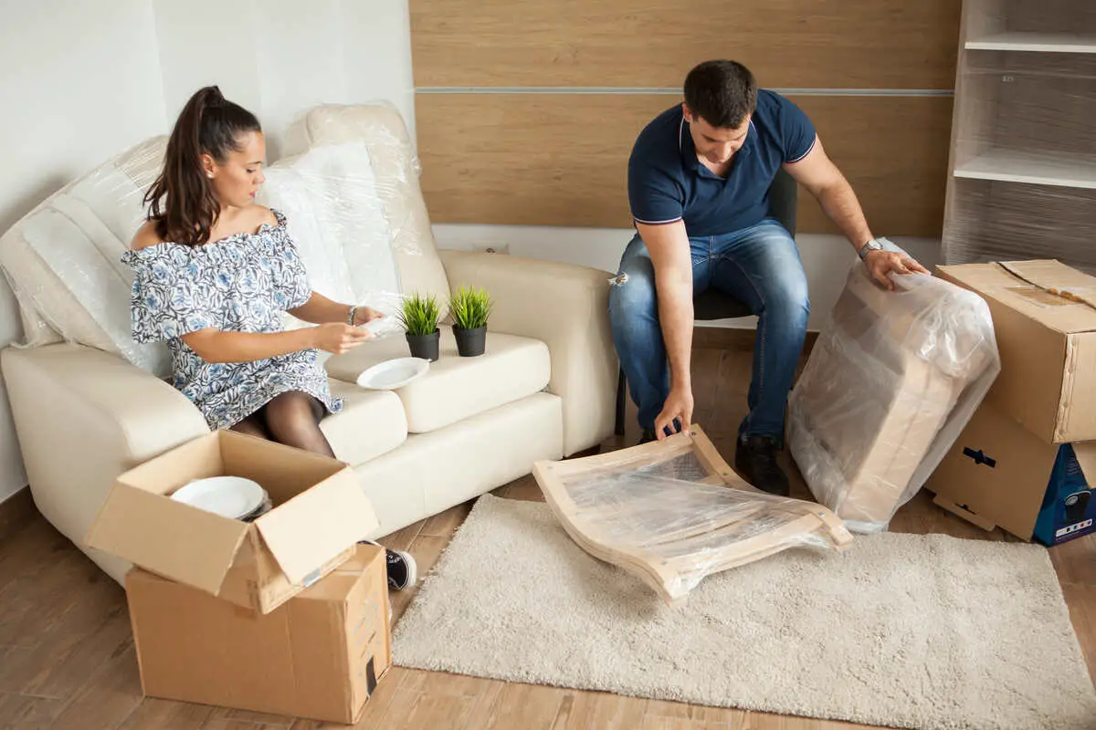 young-couple-moving-new-home-unpacking-carboard-boxes-almost-done-moving_1200x800_1_optimized