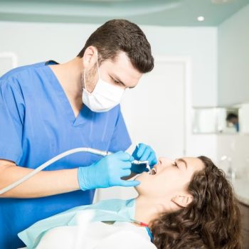 young-woman-receiving-dental-treatment-from-male-dentist-clinic_662251-2591